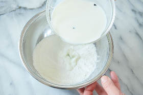最初に入れる牛乳は20~50cc程度。最初に水分を加えておくことで、卵黄の塊や粉の塊ができにくくなる。
